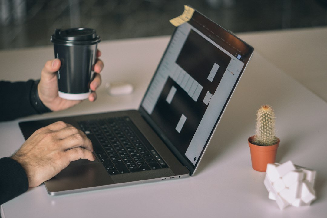 Designer reviewing a Figma prototype on a laptop before building the page in Elementor Pro