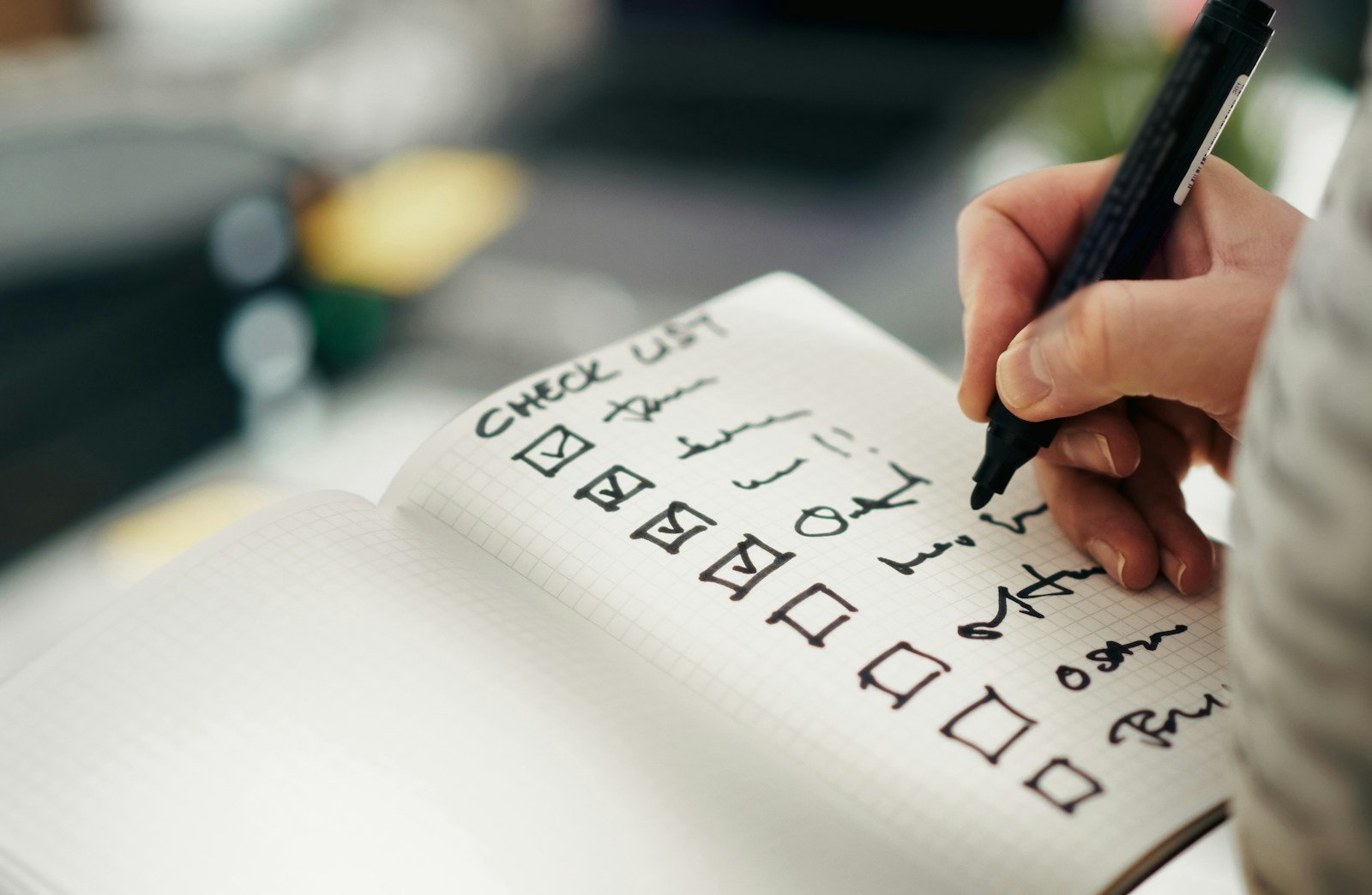 Hand marking completed tasks on a paper checklist