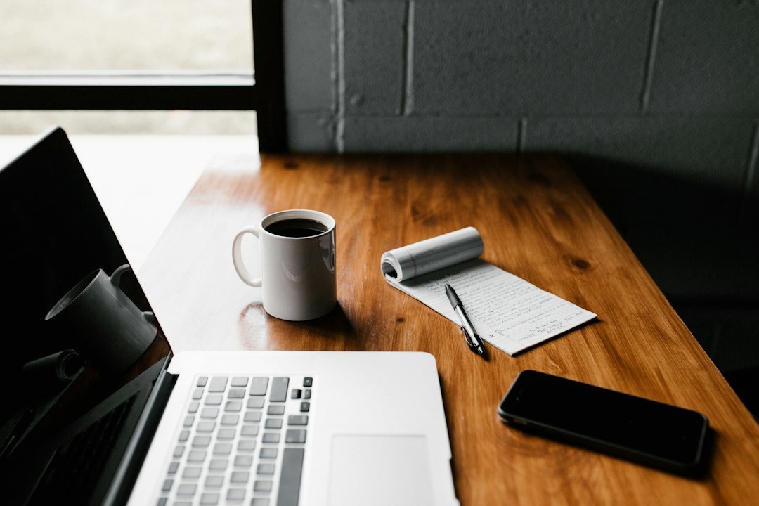 Laptop and notebook on a desk, planning the budget for a WordPress build