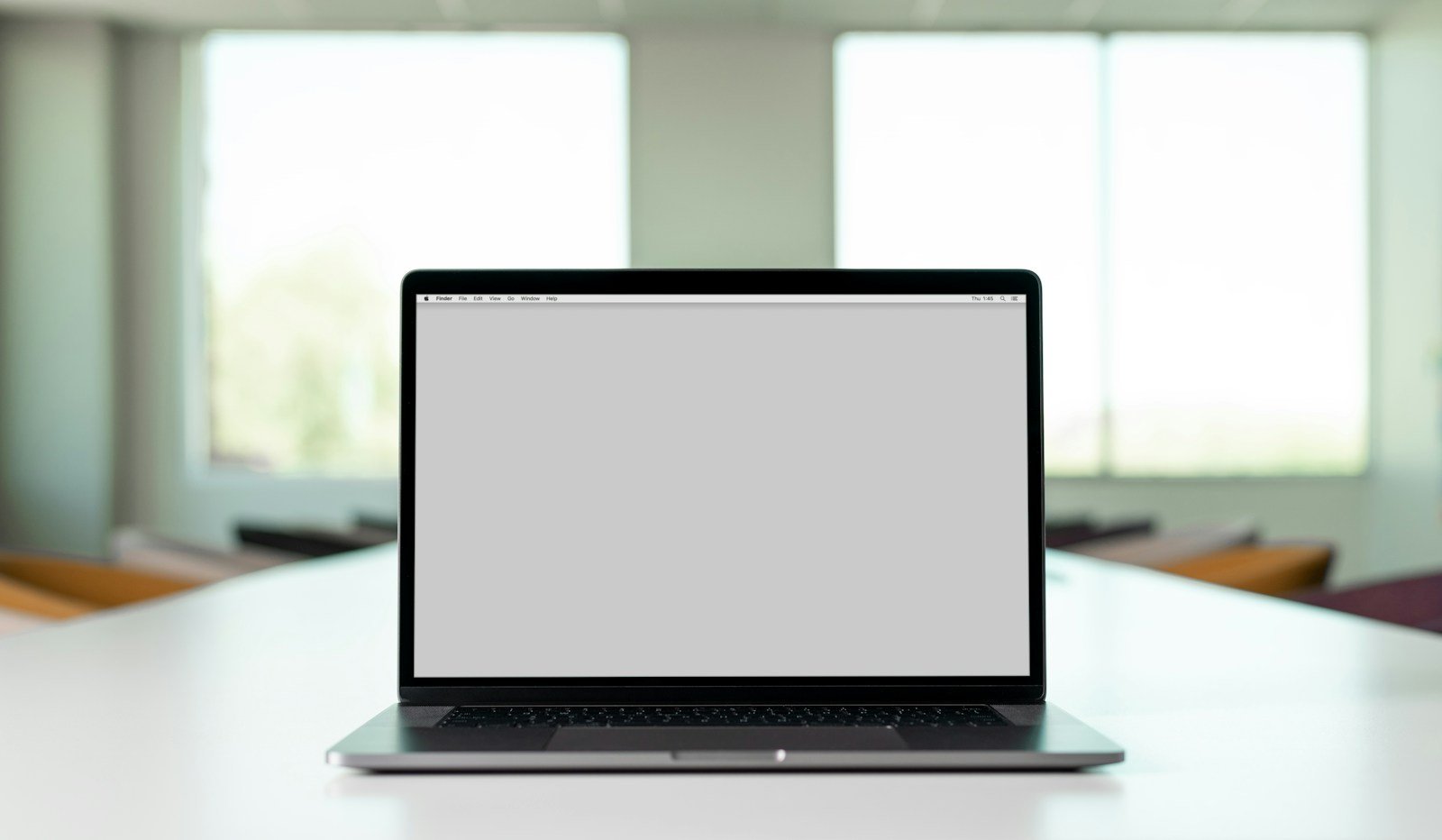 Laptop and notes on a table while a team reviews website copy